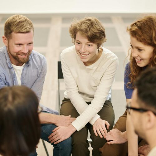 Diverse group of people sitting peacefully in a bright room.
